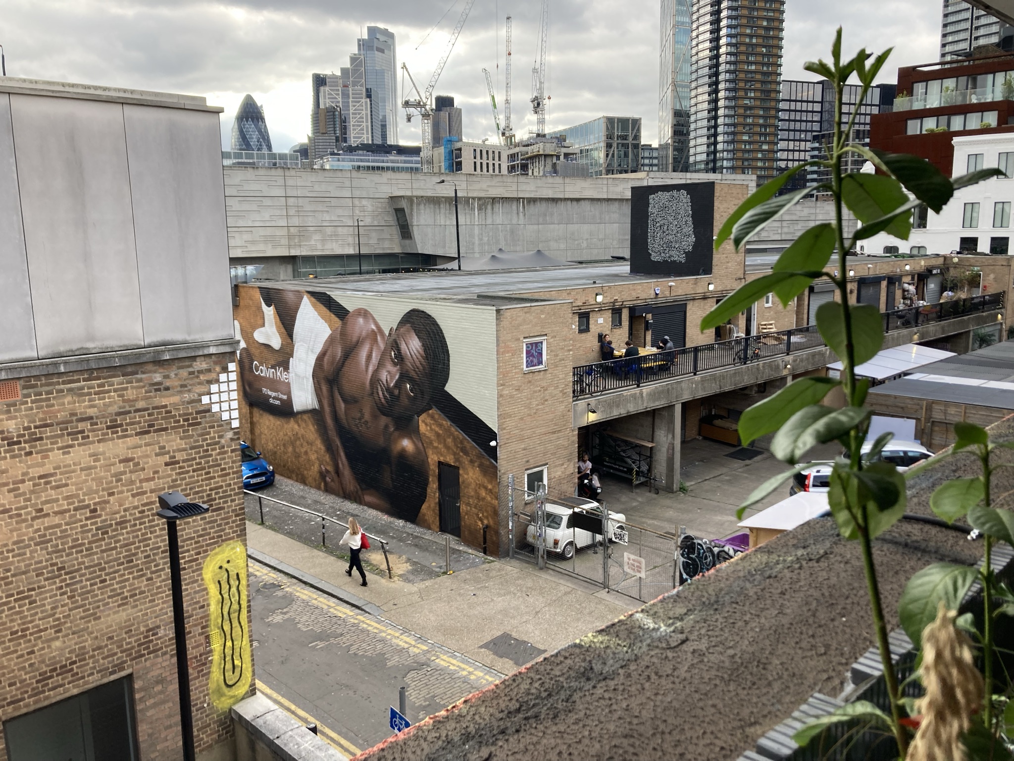 Publicité murale géante Calvin Klein sur un bâtiment de Shoreditch, avec les tours de la City de Londres en arrière-plan.